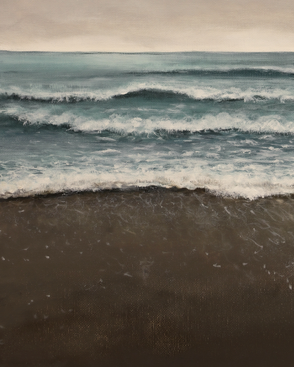 Waves crashing onto a beach with a cloudy sky above.